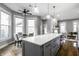 Open kitchen with stainless appliances, marble island, and view to living area at 1665 N College Ave, Indianapolis, IN 46202