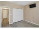 Bedroom with closet doors, gray vinyl floors, a mounted flat screen television, and an open doorway at 2282 Creekland Dr, Columbus, IN 47201