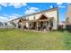 Rear exterior view of a home with two covered patios and a well-manicured lawn perfect for outdoor entertaining at 2282 Creekland Dr, Columbus, IN 47201