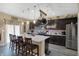 Modern kitchen featuring dark cabinets, a large island with seating, stainless steel appliances, and stylish pendant lighting at 2282 Creekland Dr, Columbus, IN 47201