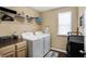 Bright laundry room featuring modern appliances, wooden cabinets, and convenient shelving for organized storage solutions at 2282 Creekland Dr, Columbus, IN 47201