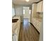 An open kitchen area with laminate countertops, white cabinets, and hardwood flooring at 2813 Collier St, Indianapolis, IN 46241