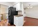Kitchen showcasing a black refrigerator next to a dining area with hardwood floors at 321 Pleasantview Dr, Greenwood, IN 46142