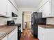 Galley kitchen with white cabinets and black appliances including a range and refrigerator at 321 Pleasantview Dr, Greenwood, IN 46142