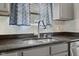 Kitchen sink with granite countertops, gray cabinets, modern faucet and fixtures, and natural lighting at 3430 Parkview Dr, Columbus, IN 47201