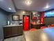 Bar and kitchenette area with sink, red refrigerator, and bar seating in the basement at 3610 Eagle Emblem Ct, Greenwood, IN 46143