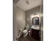 Powder room with a wood vanity, toilet, and silver light fixture at 3610 Eagle Emblem Ct, Greenwood, IN 46143