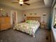 Bright bedroom featuring a queen bed, tray ceilings, and ensuite bath at 3610 Eagle Emblem Ct, Greenwood, IN 46143