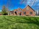 A traditional brick two-story home with a manicured lawn and mature trees under a blue sky at 3610 Eagle Emblem Ct, Greenwood, IN 46143