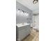 Well-lit bathroom featuring a gray vanity, shower-tub combo, and neutral tile flooring at 3661 Yellow Poplar Ct, Indianapolis, IN 46222
