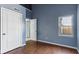 A bedroom featuring a door, a view from the window, and wood floors at 3661 Yellow Poplar Ct, Indianapolis, IN 46222