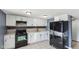 Updated kitchen with white cabinets, black appliances, and stylish backsplash detailing at 3661 Yellow Poplar Ct, Indianapolis, IN 46222