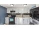 Modern kitchen with white cabinets, black appliances, and a sleek backsplash design at 3661 Yellow Poplar Ct, Indianapolis, IN 46222