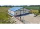 View of a blue and white barn featuring a star, sliding doors and an adjacent fenced area with a gravel lot at 3777 S 300 E, Anderson, IN 46017