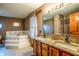 Bathroom view showcasing a soaking tub, double vanity with granite counters, and warm interior tones at 3777 S 300 E, Anderson, IN 46017