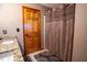 Bathroom featuring a wood door, patterned tile flooring, and a brown shower curtain at 3777 S 300 E, Anderson, IN 46017