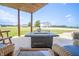 Comfortable wicker seating and a gas fire pit table on the covered patio overlooking the buildings and fields at 3777 S 300 E, Anderson, IN 46017