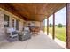 Relaxing covered patio with comfortable wicker chairs, a gas fire pit table, and rustic wood columns at 3777 S 300 E, Anderson, IN 46017