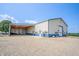 Exterior view of a metal building with a covered parking area featuring gravel driveway and entrance at 3777 S 300 E, Anderson, IN 46017