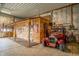 Spacious garage featuring a vintage car, American flag, and a cozy, wood-paneled recreational area at 3777 S 300 E, Anderson, IN 46017