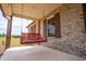 Covered porch with swing, brick facade, and view of the landscaped yard at 3777 S 300 E, Anderson, IN 46017