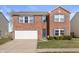 Charming two-story brick home with blue shutters, a well-maintained lawn, and a two-car garage at 380 Winterset Way, Greenwood, IN 46143