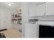 Bright laundry room with white cabinets, open shelving, and modern washer and dryer units at 380 Winterset Way, Greenwood, IN 46143