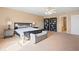 Spacious main bedroom with neutral walls, carpet, ceiling fan, large windows, and a decorative seating bench at 380 Winterset Way, Greenwood, IN 46143