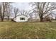 Backyard view of the cottage-style home with lawn and wood fence at 4355 W 450 S, Columbus, IN 47201