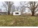 Backyard view of the white home featuring lawn and trees at 4355 W 450 S, Columbus, IN 47201