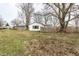 Backyard view of the white home featuring lawn and mature trees at 4355 W 450 S, Columbus, IN 47201