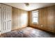 View of bedroom featuring wood paneling, window and door at 4355 W 450 S, Columbus, IN 47201