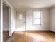 Bright living room featuring hardwood floors, a classic front door, and natural light from a window at 4355 W 450 S, Columbus, IN 47201
