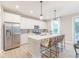 Well-appointed kitchen featuring white cabinets, stainless steel appliances, and a functional island with barstool seating at 4738 E Shadowbrook Dr, Camby, IN 46113