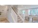 Open-concept living room featuring a view of the staircase, windows, and a comfortable seating area at 4738 E Shadowbrook Dr, Camby, IN 46113