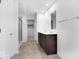 Bathroom featuring a double vanity with dark cabinets, neutral tile floors, and glass-enclosed shower at 4739 E Shadowbrook Dr, Camby, IN 46113