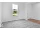Bright bedroom featuring neutral carpet, white walls, large window with green outdoor view, and white door at 4739 E Shadowbrook Dr, Camby, IN 46113