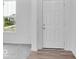 Bright entryway features white front door, light gray carpet, wood flooring and a view of the outside through a window at 4739 E Shadowbrook Dr, Camby, IN 46113
