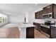 Open concept kitchen and living area features dark wood cabinets, stainless steel appliances and bright countertops at 4739 E Shadowbrook Dr, Camby, IN 46113