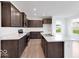 Spacious kitchen with dark wood cabinets, stainless steel appliances, light countertops and wood flooring at 4739 E Shadowbrook Dr, Camby, IN 46113