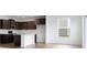 Modern kitchen featuring dark wood cabinets, stainless steel appliances, a large island with a sink and bright countertops at 4739 E Shadowbrook Dr, Camby, IN 46113