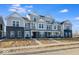 Modern townhome with gray siding, brick accents, and inviting covered porch, designed for comfortable living at 5771 Cr W 750 N, McCordsville, IN 46055