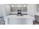 Modern kitchen with a white island, stainless steel appliances, gray cabinets, and stylish pendant lighting at 5785 Cr W 750 N, McCordsville, IN 46055