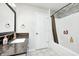 Bright bathroom featuring a modern vanity with a dark countertop and shower with decorative tile accent at 5984 Williams Dr, Plainfield, IN 46168