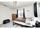 Cozy bedroom with wood-look flooring, large windows, and black metal bed frame at 5984 Williams Dr, Plainfield, IN 46168