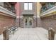Building entrance with double doors, brick facade, bench seating, and decorative flower pots for a welcoming arrival at 622 E 10Th St # 206, Indianapolis, IN 46202