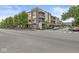 Corner condo featuring brick and siding exterior, multiple balconies, landscaping, and street parking at 622 E 10Th St # 206, Indianapolis, IN 46202