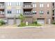 A ground-level exterior view of a modern apartment building with garage access at 622 E 10Th St # 206, Indianapolis, IN 46202