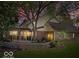 A charming two-story brick home featuring a deck and stone patio, nestled beneath a large tree at 6744 Robin Hood Ct, Indianapolis, IN 46227