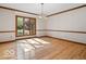 Sunlit dining room featuring hardwood floors, elegant chandelier and wainscotting at 6744 Robin Hood Ct, Indianapolis, IN 46227